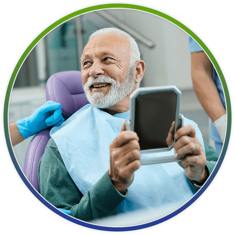 dental implant patient smiling holding mirror up and looking over at doctor