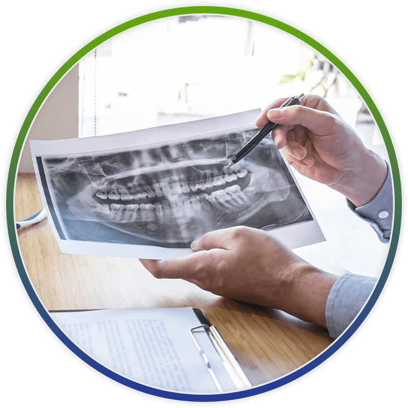dentist pointing at xray on piece of paper