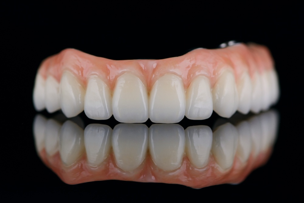 Close up animated image of a patient smiling, with a split screen showing before and after having full mouth implants put in. No text on the image.